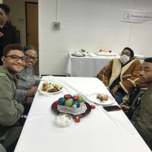 A group of people sitting at a table with food.