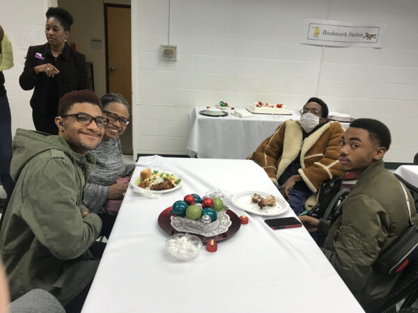 A group of people sitting at a table with food.