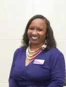 A woman in purple shirt smiling for the camera.