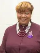 A woman with a purple necklace and a red shirt