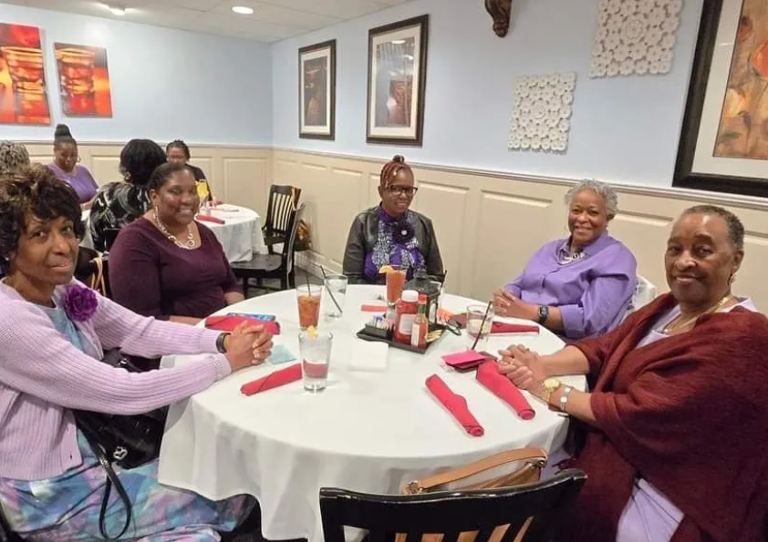 A group of people sitting at a table with drinks.