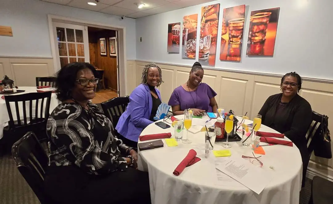 A group of people sitting at a table with food.