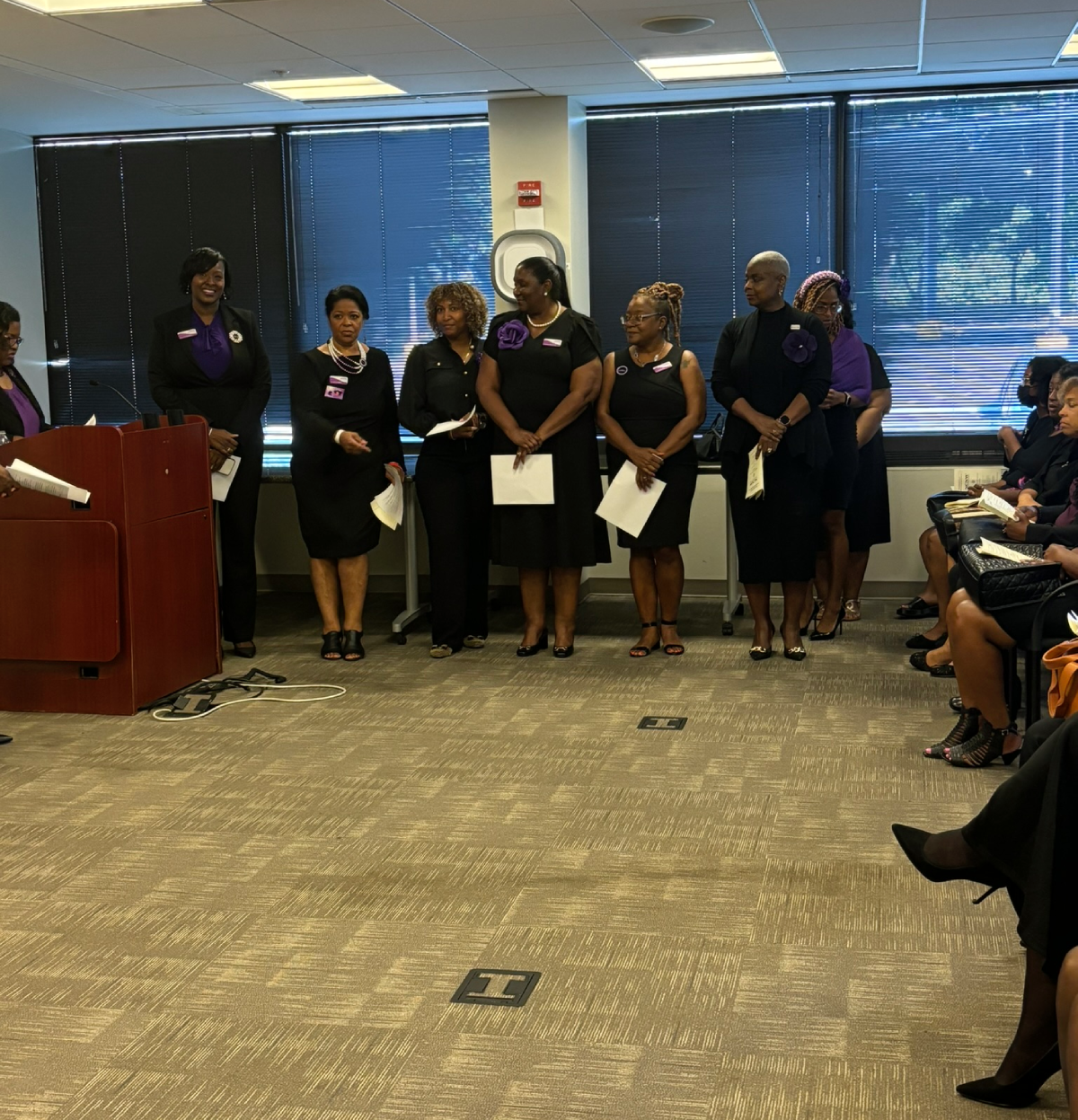 A group of women standing in front of a podium.