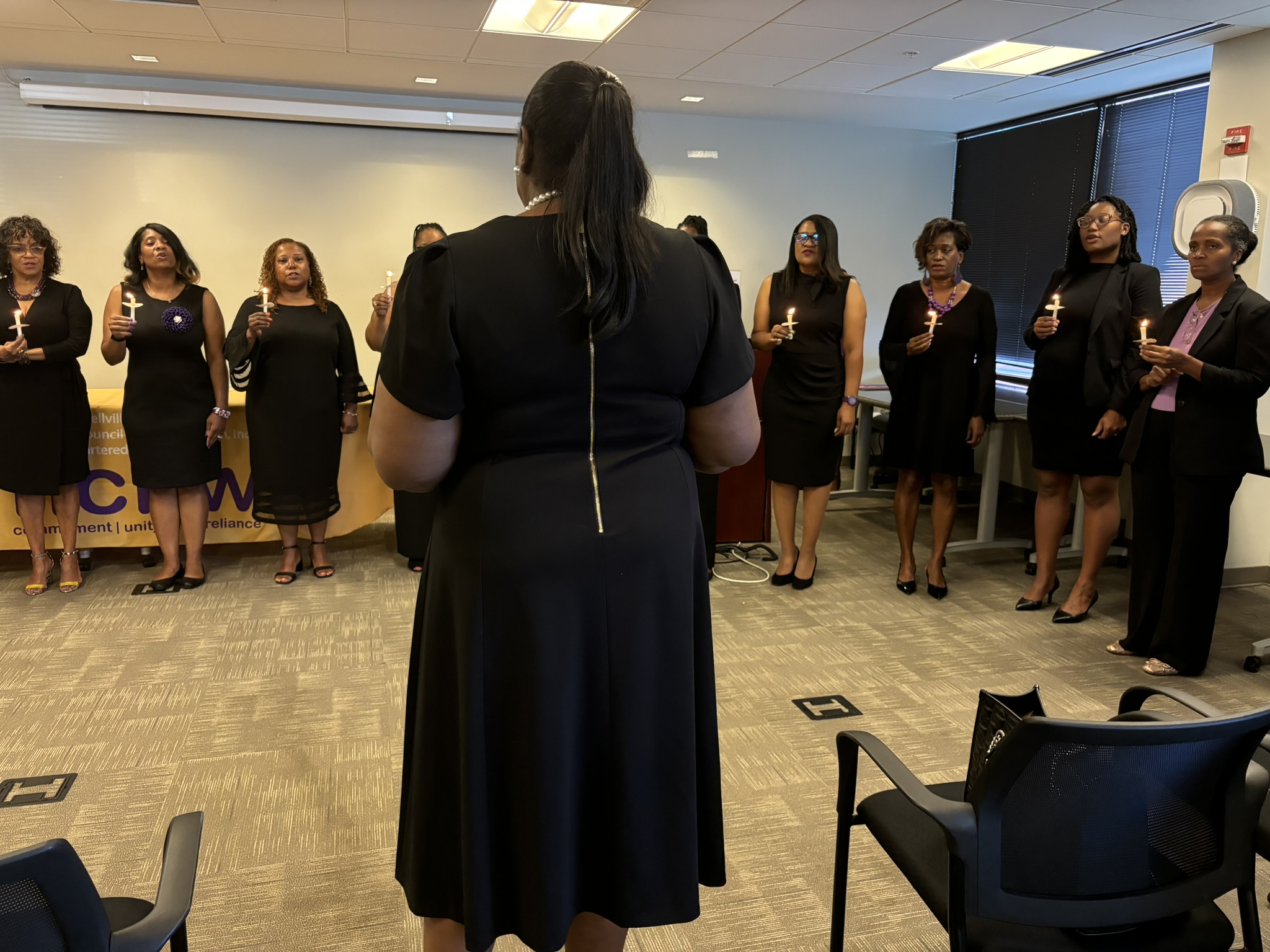 A group of women in black dresses standing around.